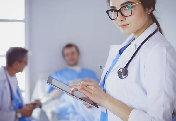 Female doctor using tablet computer in hospital lobby