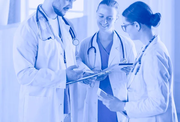 Доктор показывает что-то в планшете своей медицинской команде — стоковое фото