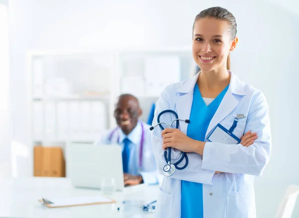 Una dottoressa sorridente con una cartella in uniforme all'interno — Foto Stock