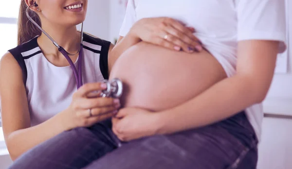 Młoda lekarka badająca kobietę w ciąży w klinice. — Zdjęcie stockowe