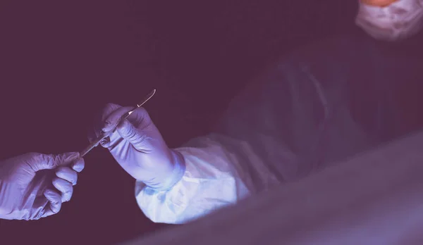 Обрезанная фотография скальпеля, сделанная врачами, выполняющими операцию. — стоковое фото