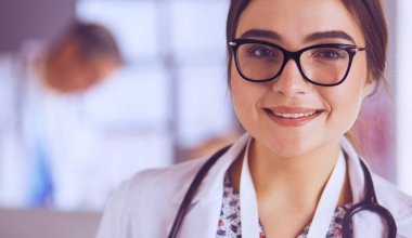 Hastane lobisinde tablet bilgisayar kullanan kadın doktor.
