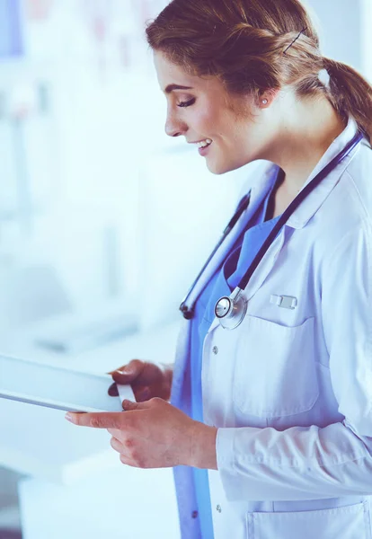 Médica usando tablet no lobby do hospital — Fotografia de Stock