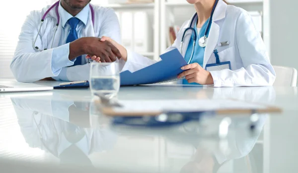 Deux jeunes gens souriants heureux serrant la main au bureau. Médecins. Travail d'équipe — Photo