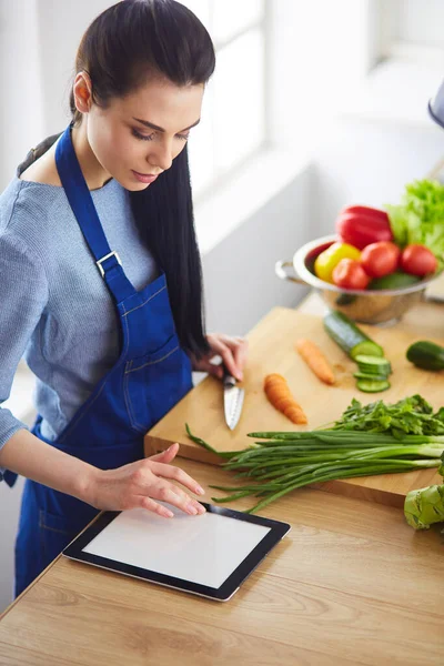 Junge Frau schneidet Gemüse in Küche zu Hause — Stockfoto