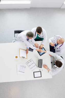 Tıbbi ekip masaya oturuyor ve tartışıyor.