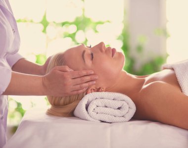 Genç bir kadın masaj salonundan zevk alıyor.