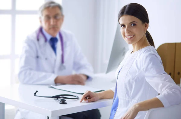 Two doctors smiling in consulting room in hospital — Stock Photo, Image