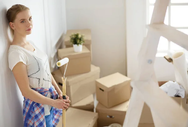 Feliz sonriente mujer pintura interior de la pared de la nueva casa —  Fotos de Stock