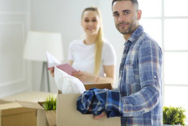 Yeni evli bir çift kutuları boşaltıyor ve yeni bir eve taşınıyor. Pozitif duygu.