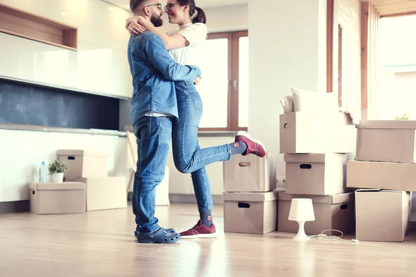 Счастливая пара обнимается в своем новом доме — стоковое фото