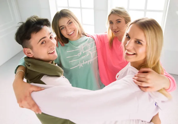 Boldog mosolygó barátok, együtt álló és ölelkező fiatalok csoportja — Stock Fotó