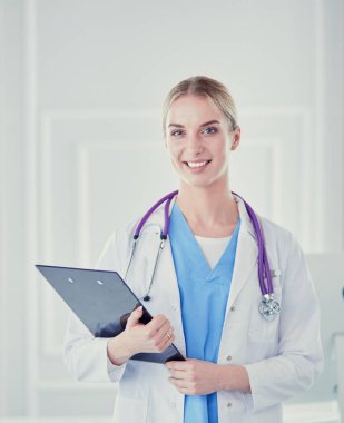 Kadın doktor hastanede dosyayla bekliyor.