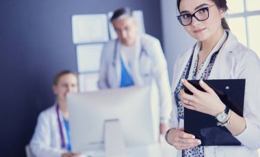 Kadın doktor hastanede steteskopla dikiliyor.