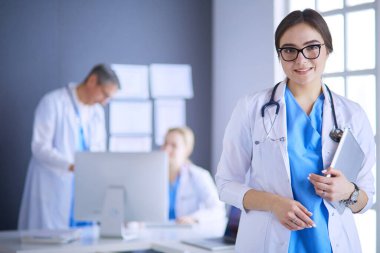 Hastane lobisinde tablet bilgisayar kullanan kadın doktor.