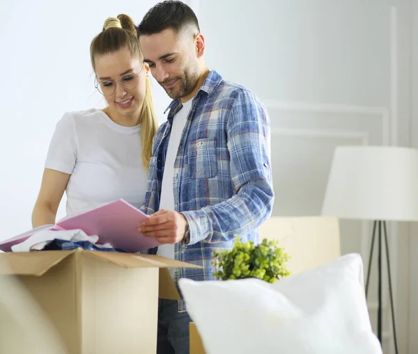 Um casal recém-casado a desempacotar caixas e a mudar-se para uma nova casa. Emoção positiva . — Fotografia de Stock