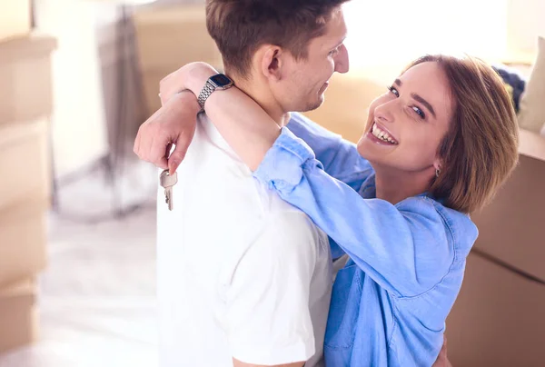 Glücklich lächelndes junges Paar zeigt Schlüssel für sein neues Haus — Stockfoto