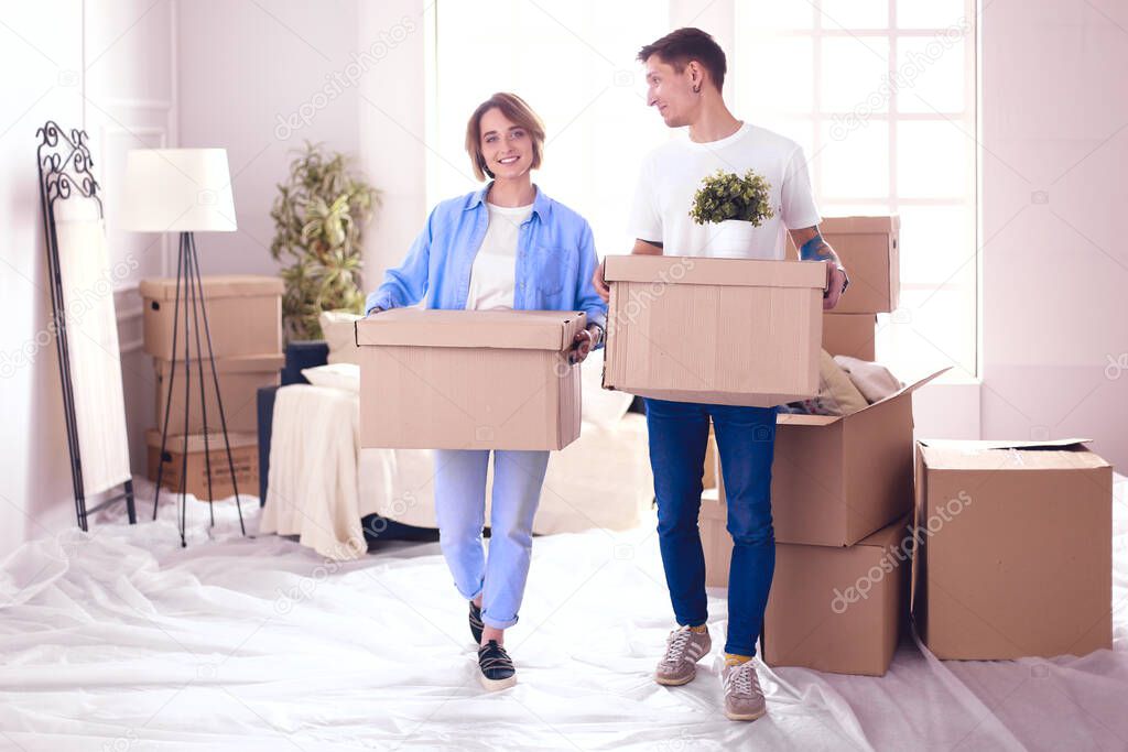 A girl and a guy holding boxes for moving the hands and looking inside box