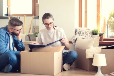 Mutlu genç çift açma veya kutu ambalaj ve yeni evine taşıdıktan