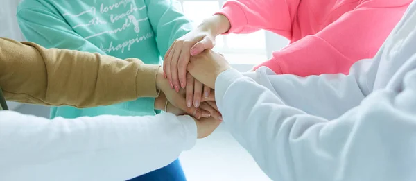 Tinédzserek csoportja, akik egymásra rakják a kezüket, egység és szolidaritás — Stock Fotó