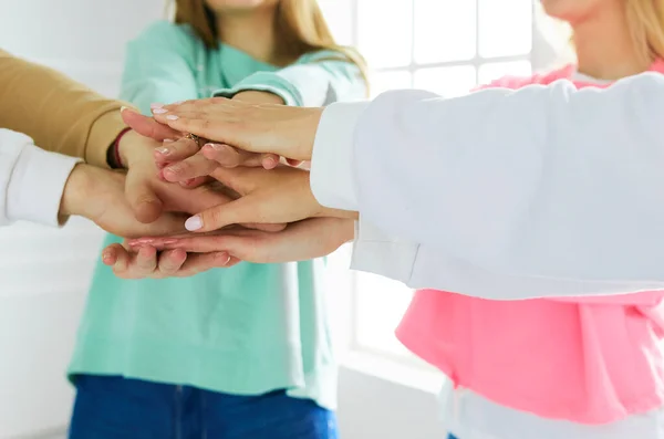 Gente uniendo las manos, mujeres jóvenes de pie juntas — Foto de Stock