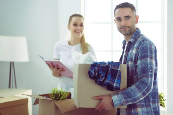 Um casal recém-casado a desempacotar caixas e a mudar-se para uma nova casa. Emoção positiva . — Fotografia de Stock