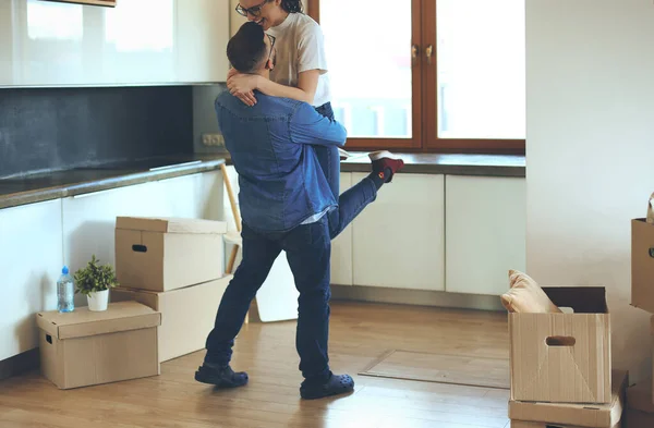 Abrazar a una pareja celebrando mudarse a un nuevo hogar —  Fotos de Stock