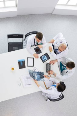 Tıbbi ekip masaya oturuyor ve tartışıyor.