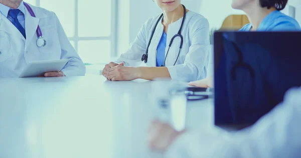 Equipo médico serio discutiendo casos de pacientes en un consultorio luminoso —  Fotos de Stock