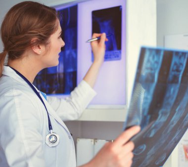 Genç, profesyonel kadın doktor hastaların röntgenlerini çekiyor.