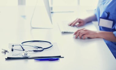 Masada oturan gülümseyen güzel genç bayan doktor.