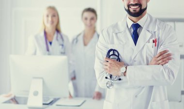 Tıbbi grubun önünde genç bir erkek doktor.