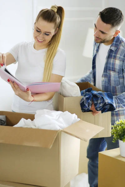 Egy házaspár dobozokat pakol ki és új otthonba költözik. Pozitív érzelem. — Stock Fotó