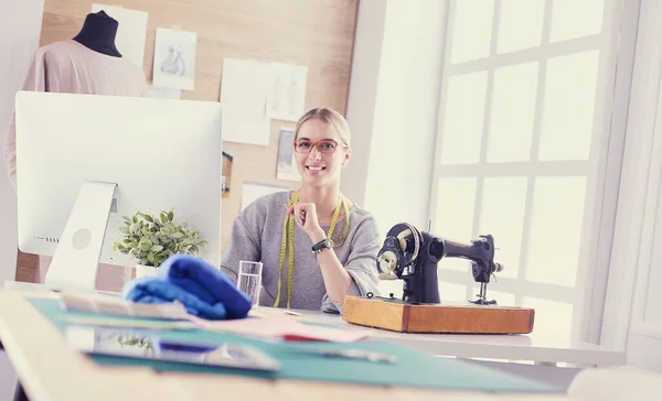 Красива молода дівчина на фабриці зі швейною машинкою за столом — стокове фото