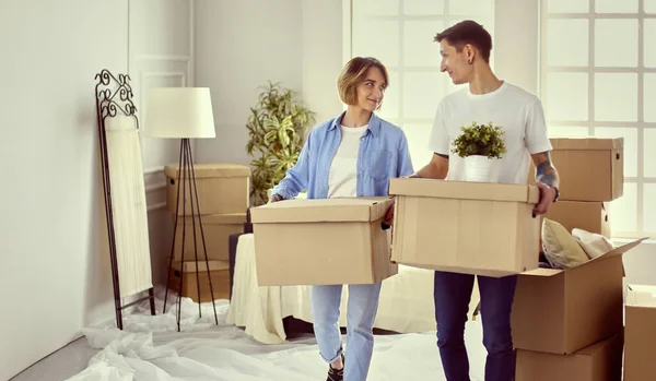 Casal segurando caixas para mover as mãos e olhando dentro da caixa — Fotografia de Stock