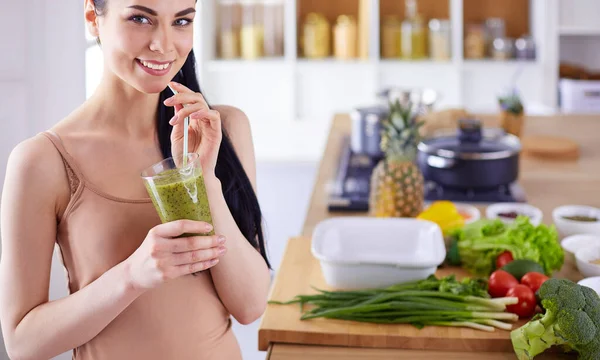 Giovane donna con vetro di frullato sano saporito a tavola in cucina — Foto Stock