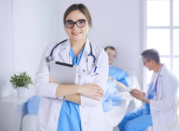 Médico femenino usando tableta en el vestíbulo del hospital —  Fotos de Stock