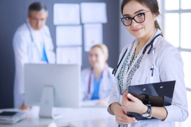 Kadın doktor hastanede steteskopla dikiliyor.