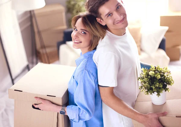 Casal segurando caixas para mover as mãos e olhando dentro da caixa — Fotografia de Stock