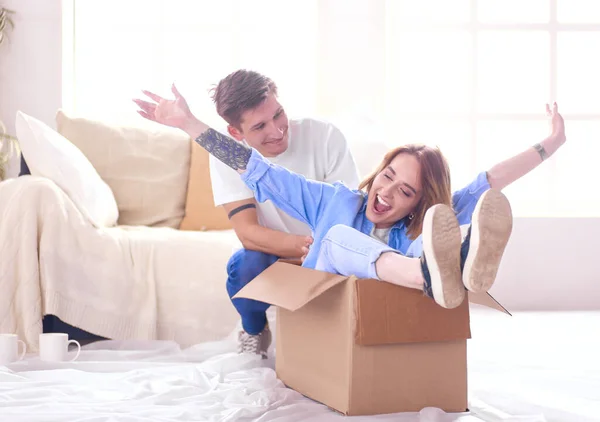 Movendo-se, conceito de casa e casal - casal sorridente relaxante no sofá em nova casa — Fotografia de Stock