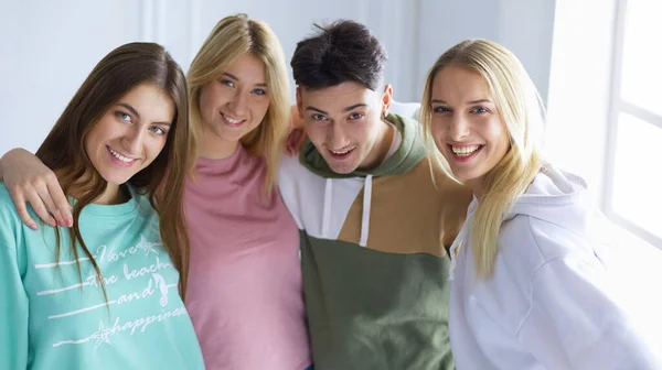 Gelukkige glimlachende vrienden, groep jongeren die samen staan en omhelzen — Stockfoto