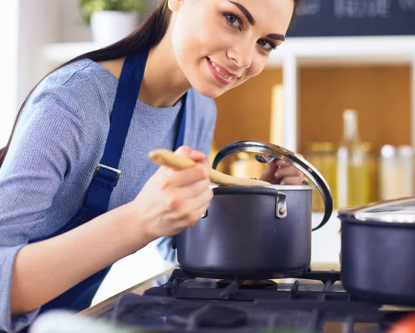 Cuisson femme dans la cuisine avec cuillère en bois — Photo