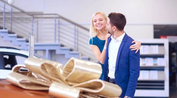 Een man maakt een geschenk - een auto aan zijn vrouw. Ze is hier verbaasd over. Ze zijn erg blij over — Stockfoto