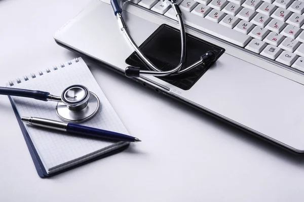 Estetoscópio com área de transferência e laptop na mesa — Fotografia de Stock