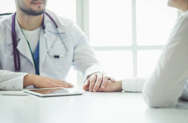 Erkek doktor ambulanstaki hastayı rahatlatıyor.