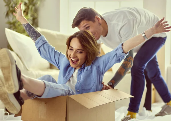 Movendo-se, conceito de casa e casal - casal sorridente relaxante no sofá em nova casa — Fotografia de Stock