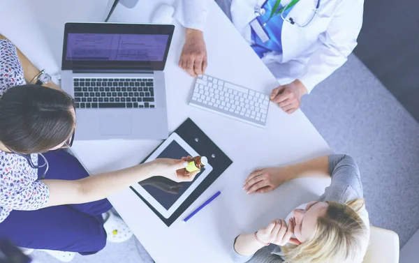 Médico e paciente discutindo algo enquanto se senta na mesa. Conceito de medicina e cuidados de saúde — Fotografia de Stock