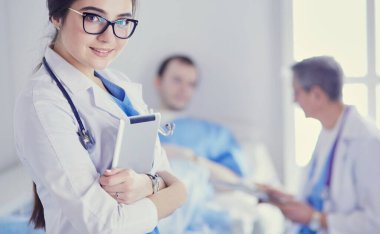 Hastane lobisinde tablet bilgisayar kullanan kadın doktor.