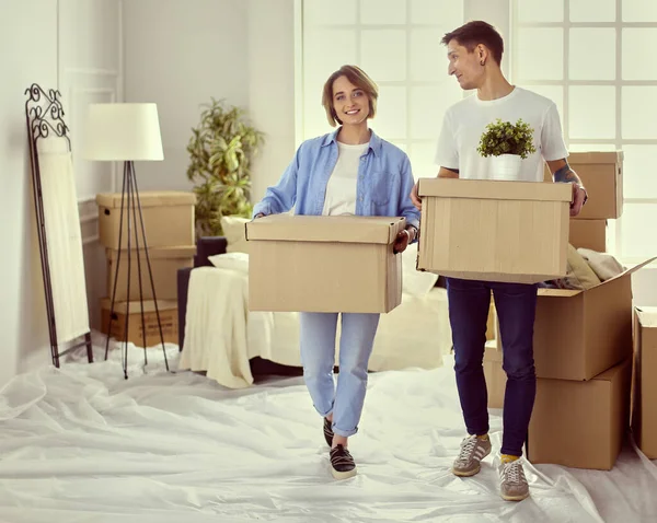 A girl and a guy holding boxes for moving the hands and looking inside box — Stock Photo, Image
