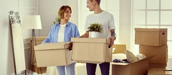 Casal segurando caixas para mover as mãos e olhando dentro da caixa — Fotografia de Stock